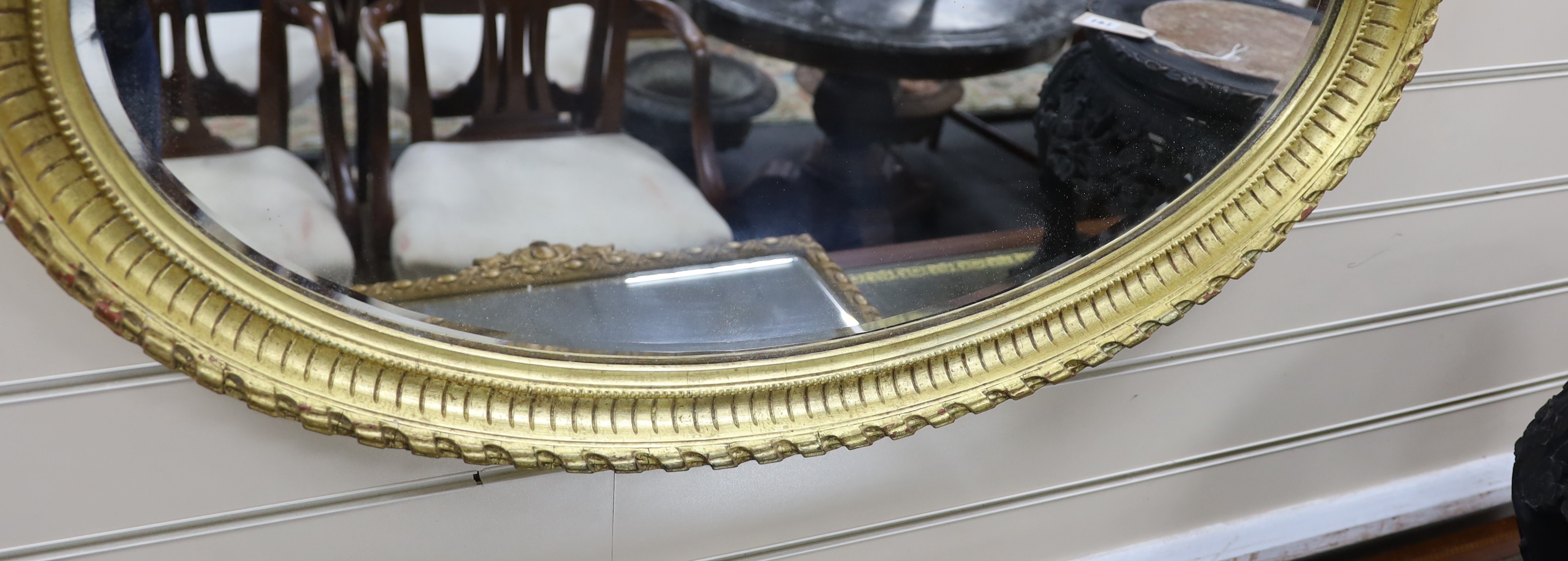 An oval moulded gilt wall mirror width 86cm, height 56cm.